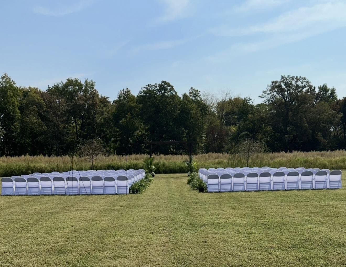 Outdoor ceremony seating set up in the open field at Mirewood in summer